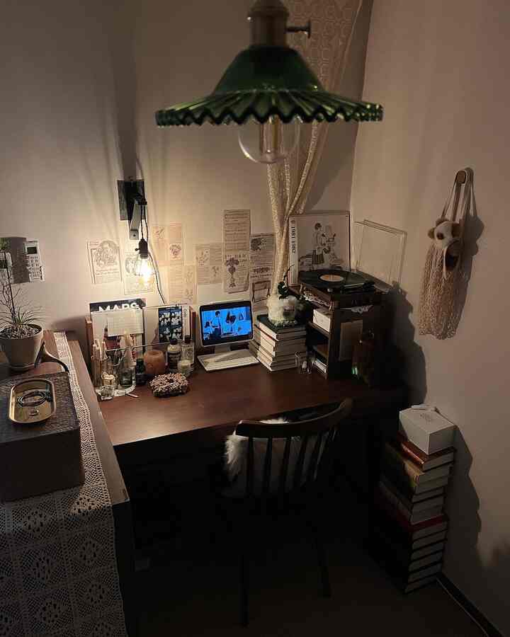 温かみのある照明とヴィンテージ小物が配置された狭いホームオフィス、居心地よく集中できる空間