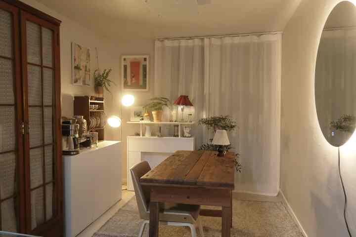 ホワイトとウッドトーンが調和したヴィンテージ風リビング、壁掛け大型円形鏡と多彩な照明が温かみのある空間を演出