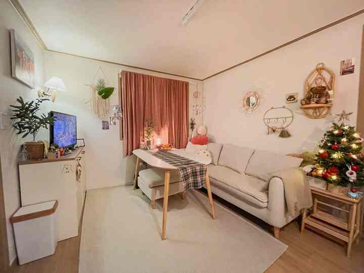 ホワイトとブラウンの色調の一人暮らしのリビング、ソファとダイニングテーブルが配置された居心地の良い空間