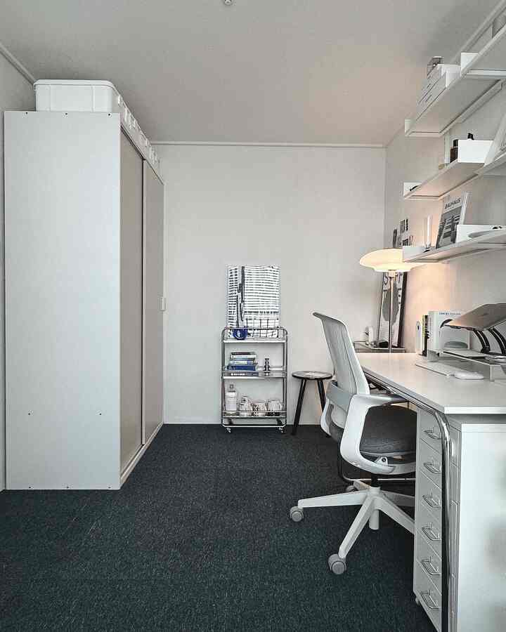 白い壁と天井、モダンな棚とデスク、オフィスチェアが配置された狭いホームオフィスのインテリア