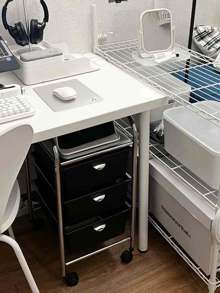 ホワイトトーンのコンパクトなホームオフィス空間、収納トロリーとメタルシェルフが配置された整然としたインテリア