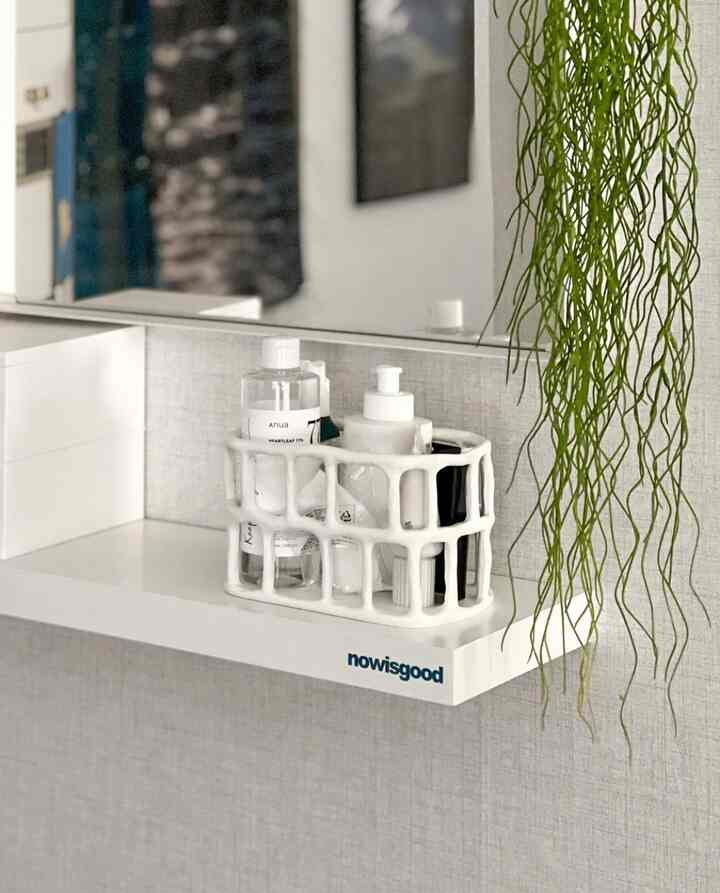 清潔感のある白い棚にIKEAの鏡とセラミックバスケットが整理されたバスルームのインテリア