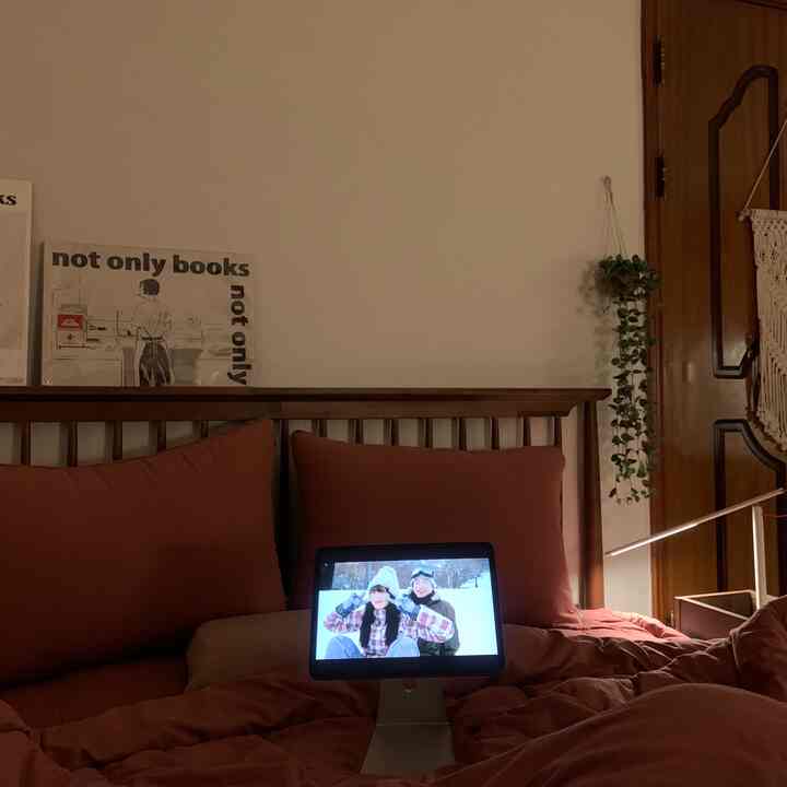 暖かいブラウンのトーンの寝室、木製ベッドと調節可能な照明が配置された雰囲気のあるインテリア