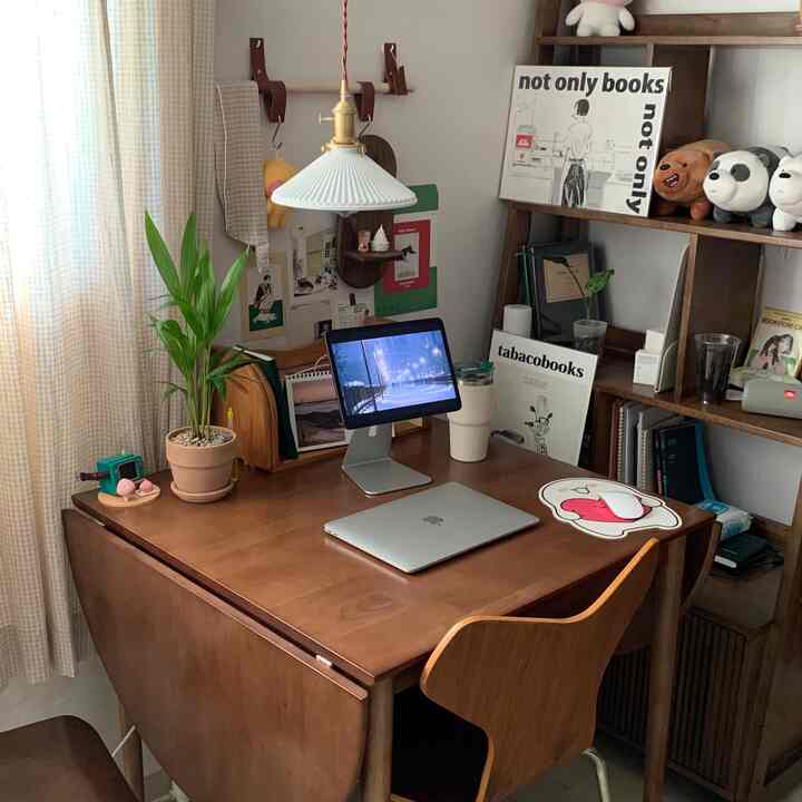 ナチュラルなブラウン調のホームオフィス、机の上にノートパソコンと植物が置かれた落ち着いた作業スペース