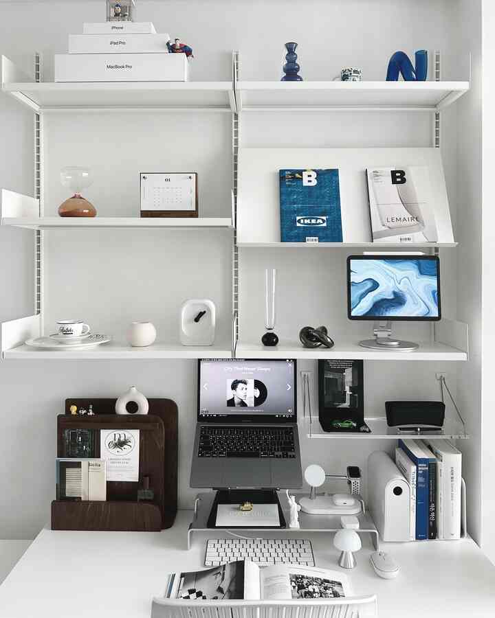 白を基調としたホームオフィス、整然としたデスクと棚に本やオブジェが配置されたモダンな雰囲気のインテリア