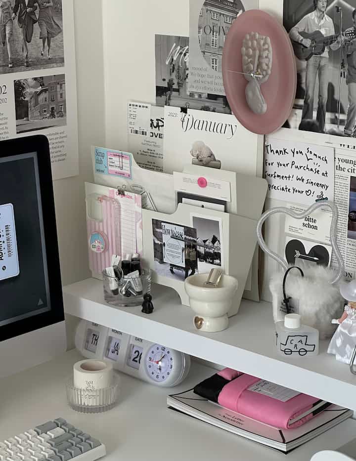 白を基調としたホームオフィス、壁にポスターと時計が配置された印象的な作業空間