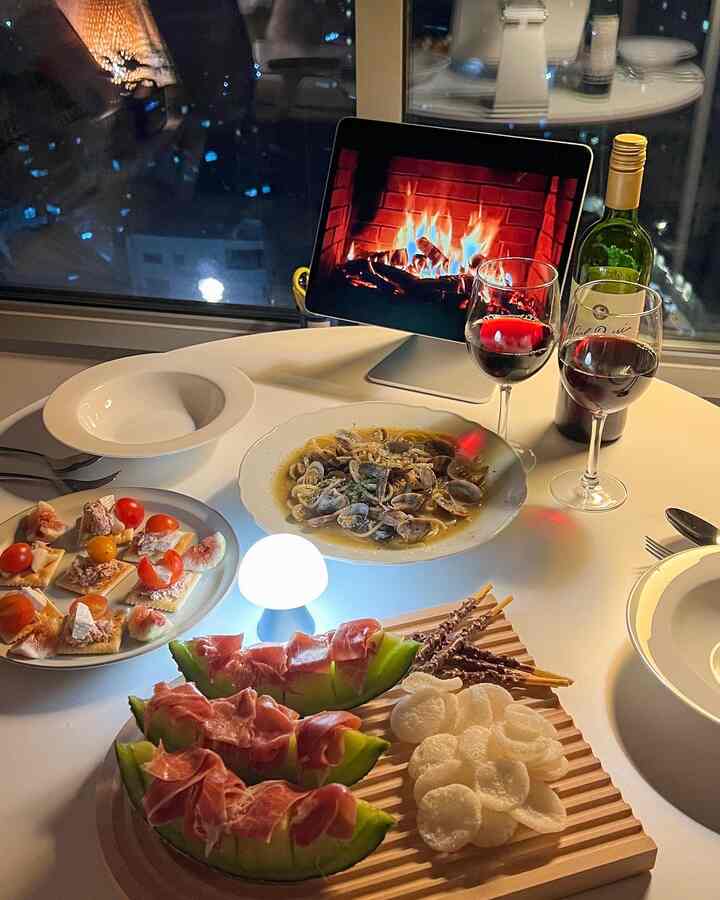 白を基調とした丸テーブルにワイングラスや皿、ムードランプが配置された雰囲気のあるホームパーティースペース