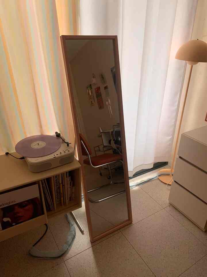 ベージュとホワイトの色調のウォークインクローゼット、全身鏡とシンプルな家具が配置された落ち着いた雰囲気のインテリア