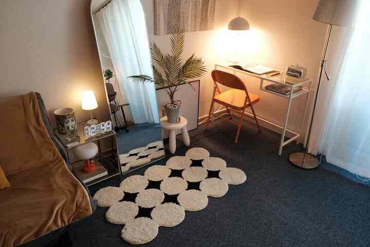 ホワイトとブラウンの色調が調和したミッドセンチュリーモダンの小さなホームオフィス、ミニラグとフロアランプが雰囲気のあるインテリアを演出