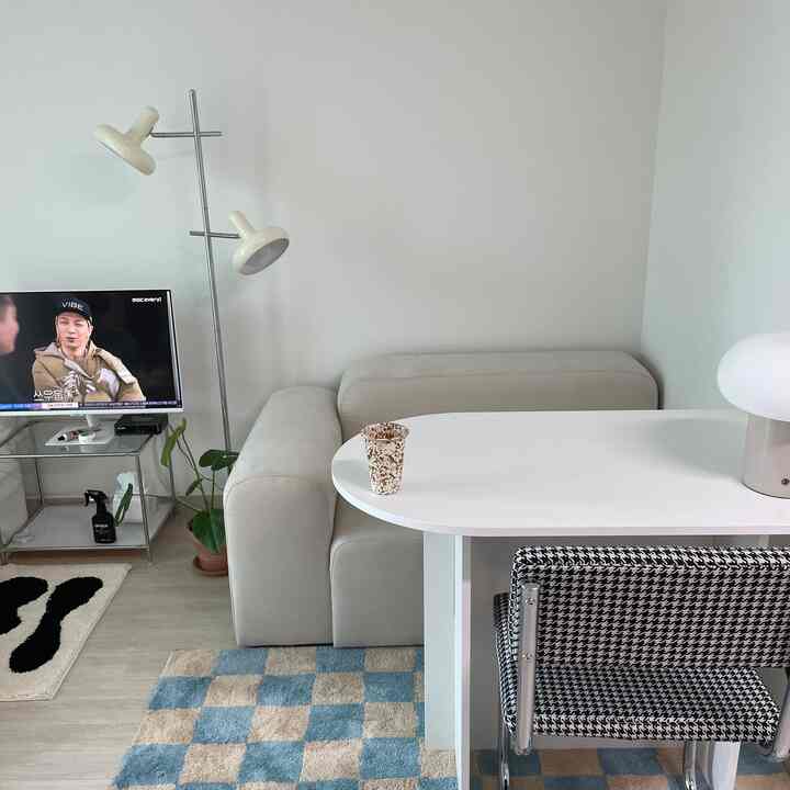 ホワイトとベージュ調のリビング、ソファとダイニングテーブルが配置された自然で落ち着いた雰囲気の空間