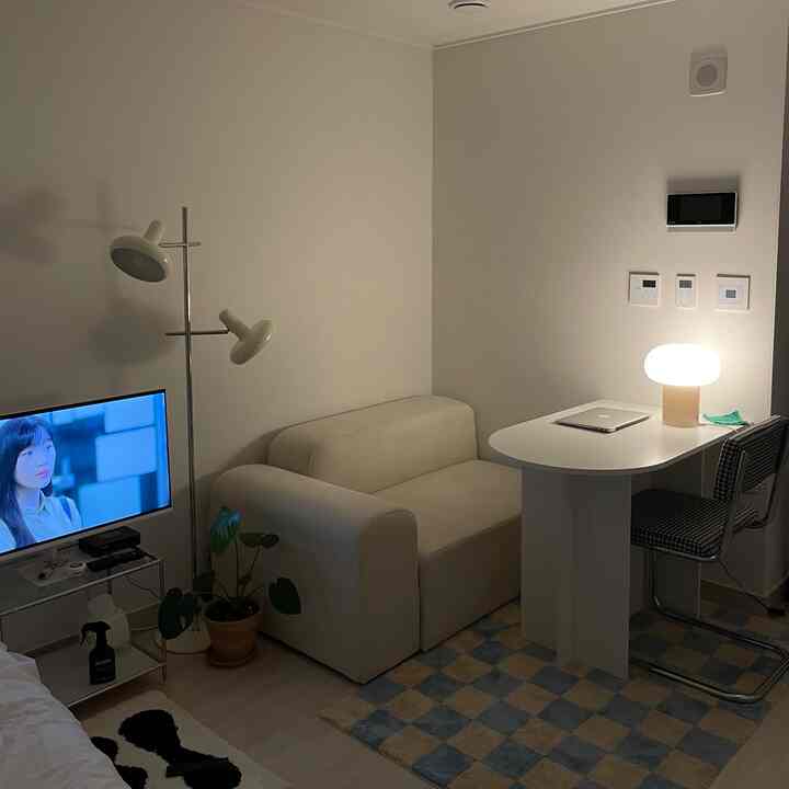 ナチュラルカラーのミッドセンチュリーモダンスタイル、ベージュソファと2つの間接照明が配置されたコンパクトなリビングルーム、落ち着いた雰囲気のあるインテリア