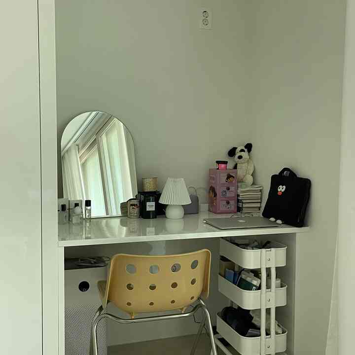 ホワイトトーンのビルトインデスクと淡いイエローの椅子が配置されたシンプルで清潔感のある勉強・化粧スペース