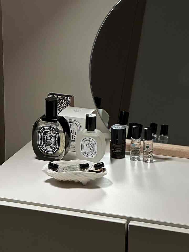 ホワイトトーンの化粧台に様々な香水とディフューザーが置かれたナチュラルモダンな雰囲気のパウダールーム