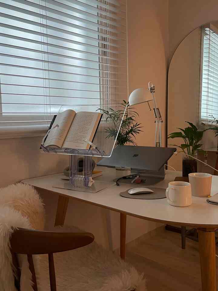 白と木目調の調和が取れたホームオフィス、読書台とPCスタンドが配された落ち着いた作業空間