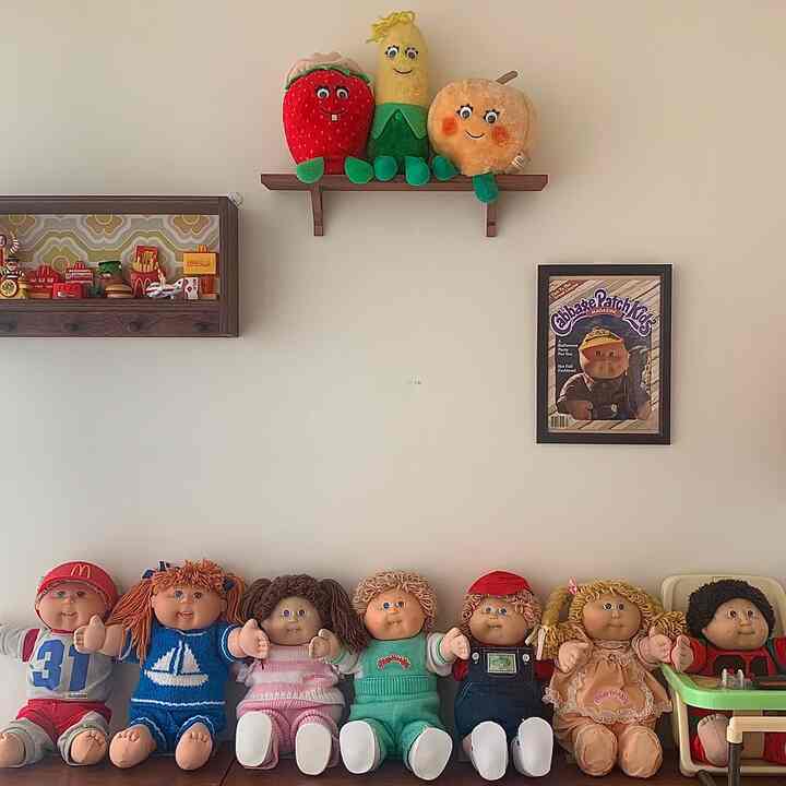 自然な色調の子供部屋、壁にヴィンテージのキャベツパッチキッズドールとマクドナルドのヴィンテージグッズが飾られた雰囲気のあるインテリア