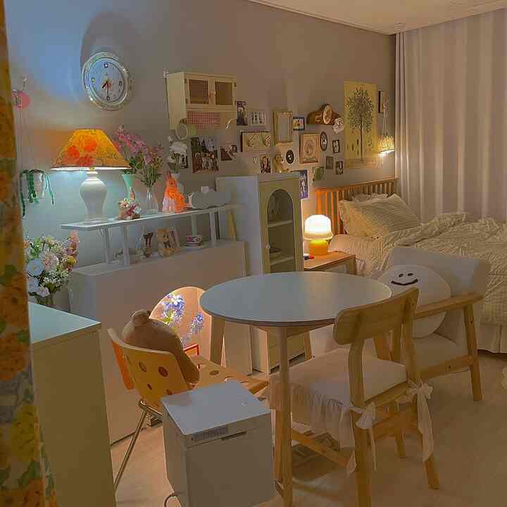 パステルカラーと木目調の家具、複数のヴィンテージ照明が配置された雰囲気のある一人暮らしのリビング