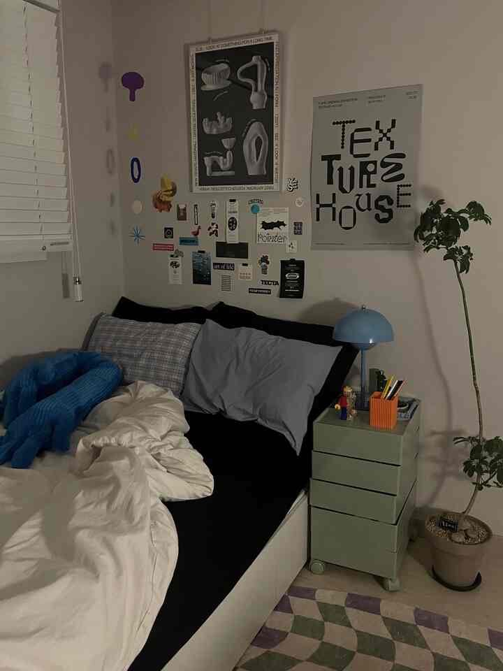 黒と白の調和が美しい寝室、きちんとしたベッドとミニマルな収納家具、植物が配置された落ち着いた夜の雰囲気のインテリア