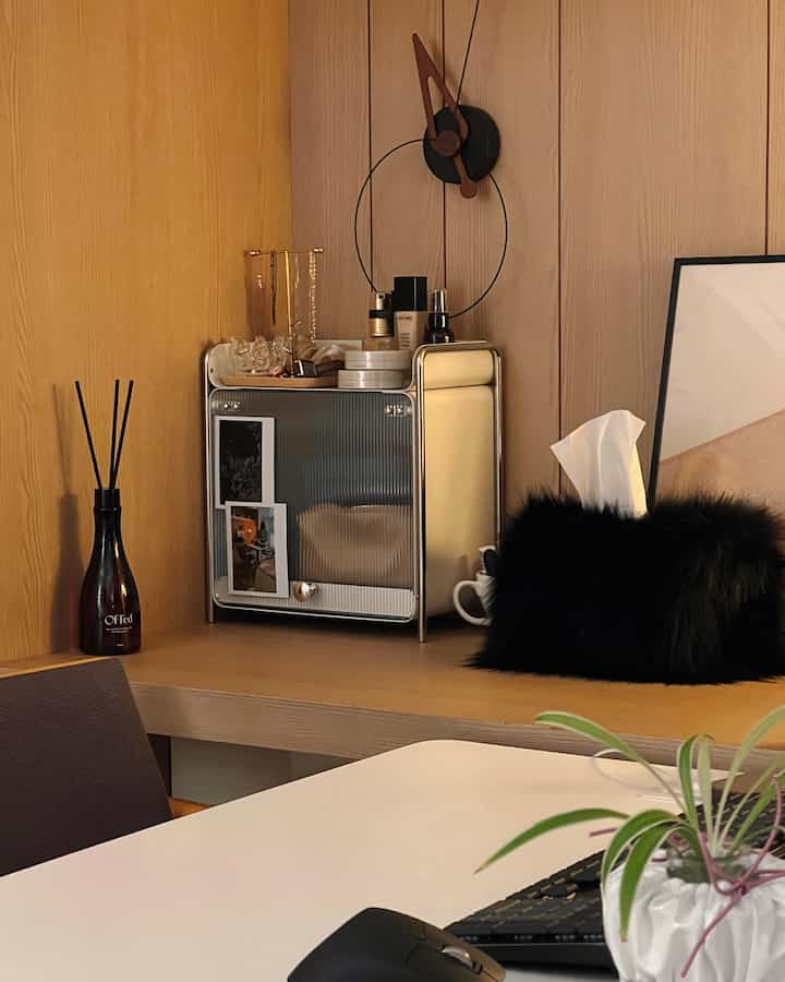 温かみのある木目調の壁と金属製の収納キャビネットが配置された、モダンで整ったホームオフィス空間