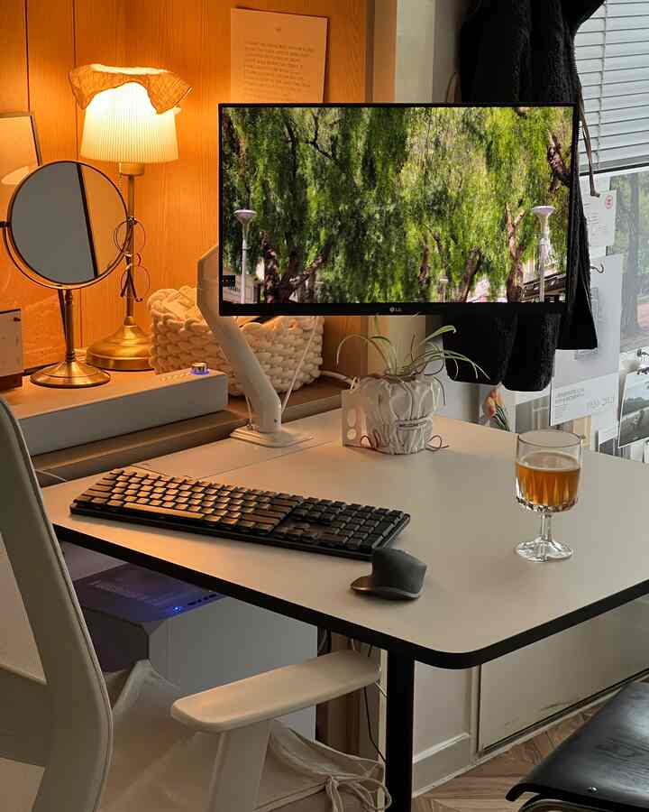 暖かいナチュラルトーンの木製壁と白いデスク、モニターとキーボードが配置されたコンパクトな一人暮らしのホームオフィス