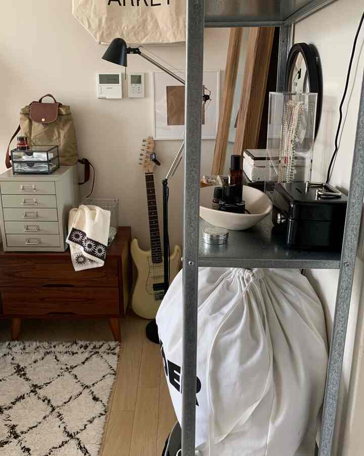 ナチュラルな色調のコンパクトなワンルーム、全身鏡や棚、チェストが配置され、落ち着いた印象的な空間