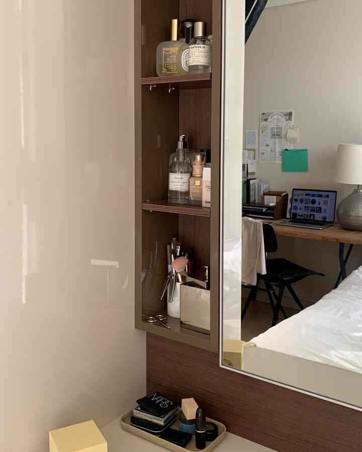 ナチュラルな色調の寝室、化粧台と鏡が中心に配置され、その隣にデスクとベッドがある温かみのあるインテリア