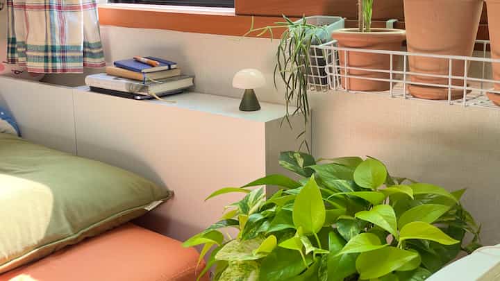 ナチュラルトーンの寝室、白い隙間収納棚と緑の植物が配置された雰囲気のあるインテリア