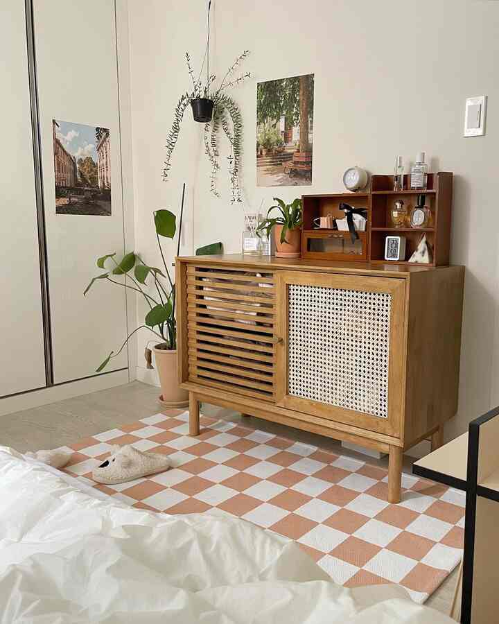 ベージュとホワイトの色調の寝室、木製キャビネットと植物が調和した雰囲気のあるインテリア