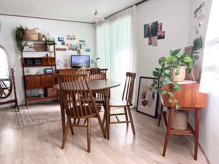 明るいホワイトと木目調のリビング兼ダイニング、木製ダイニングテーブルと椅子が配置されたナチュラルな空間