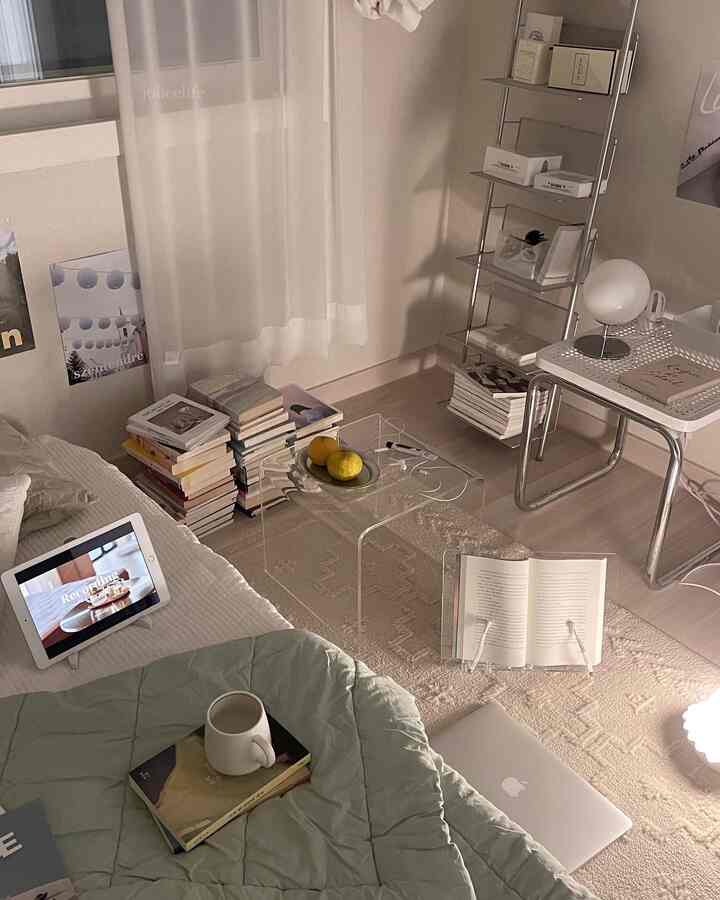 ホワイトとベージュの色調の寝室、透明なアクリルのミニテーブルとメタル棚が配置された温かみのあるミッドセンチュリーモダンなインテリア