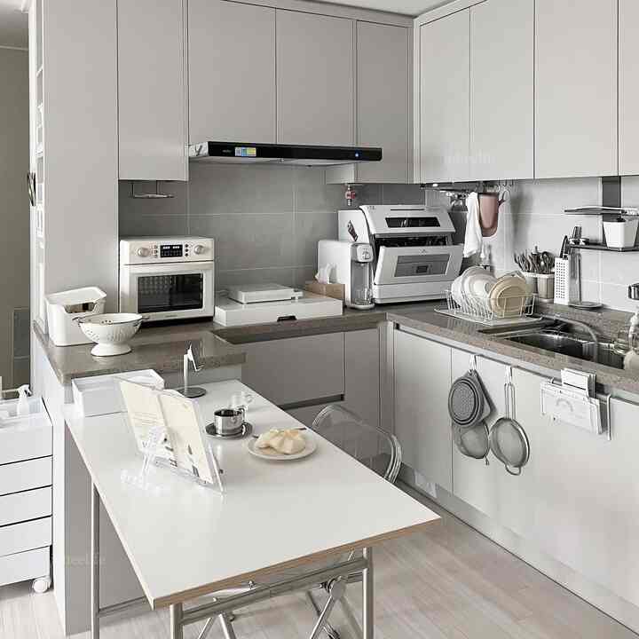 ホワイトとグレーを基調としたモダンなキッチン、調理台と収納キャビネットが配置された実用的な空間