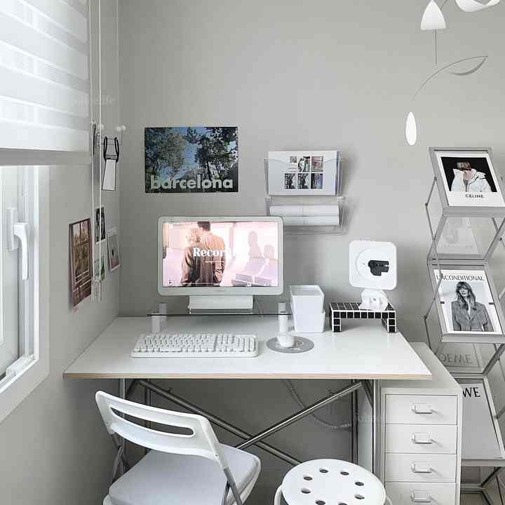 ホワイトとグレーの色調の書斎空間、整然としたデスクと椅子、モビールや額縁、ポスターが配置されたミニマルなホームオフィスインテリア