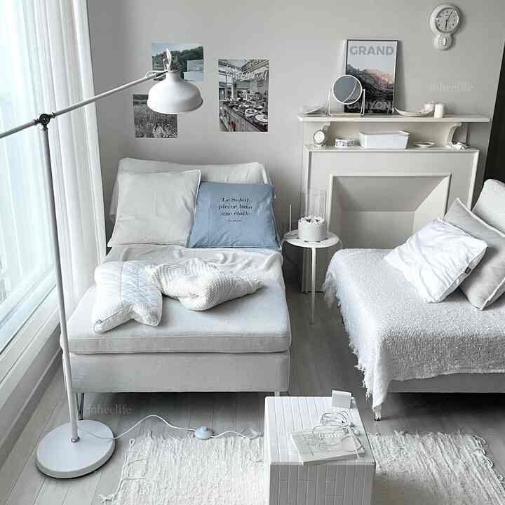 ホワイトとスカイブルーのトーンによる明るくシンプルなモダンなリビング、ソファとクッション、フロアランプが配された空間