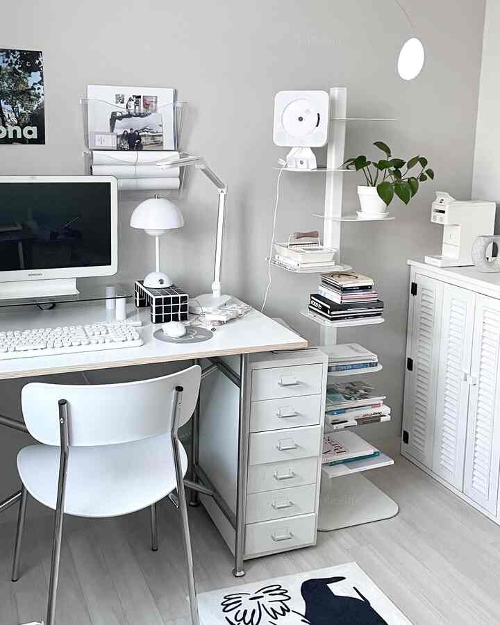 白とグレーのトーンの書斎空間、白いデスクと椅子、棚には本と植物が配置されたミニマルな雰囲気のインテリア