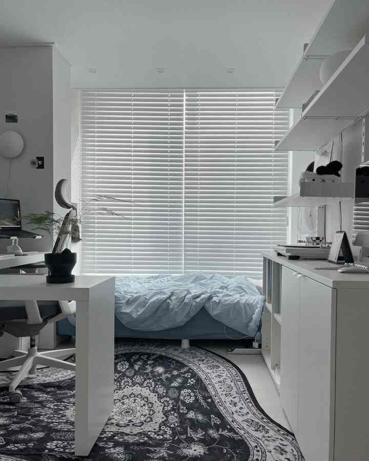 ホワイトとブルーのトーンで統一された、清潔感のあるモダンな一人暮らしの寝室兼ホームオフィス