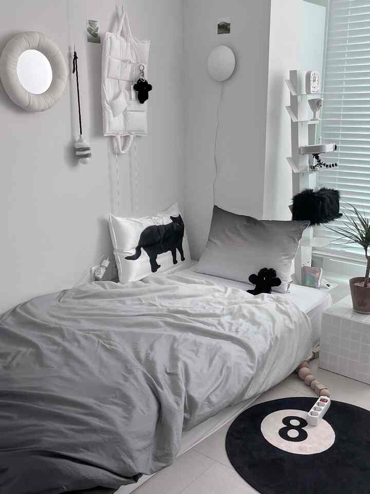 モノトーンの寝室、グラデーションの寝具と黒猫の枕カバーが印象的なミニマルなインテリア