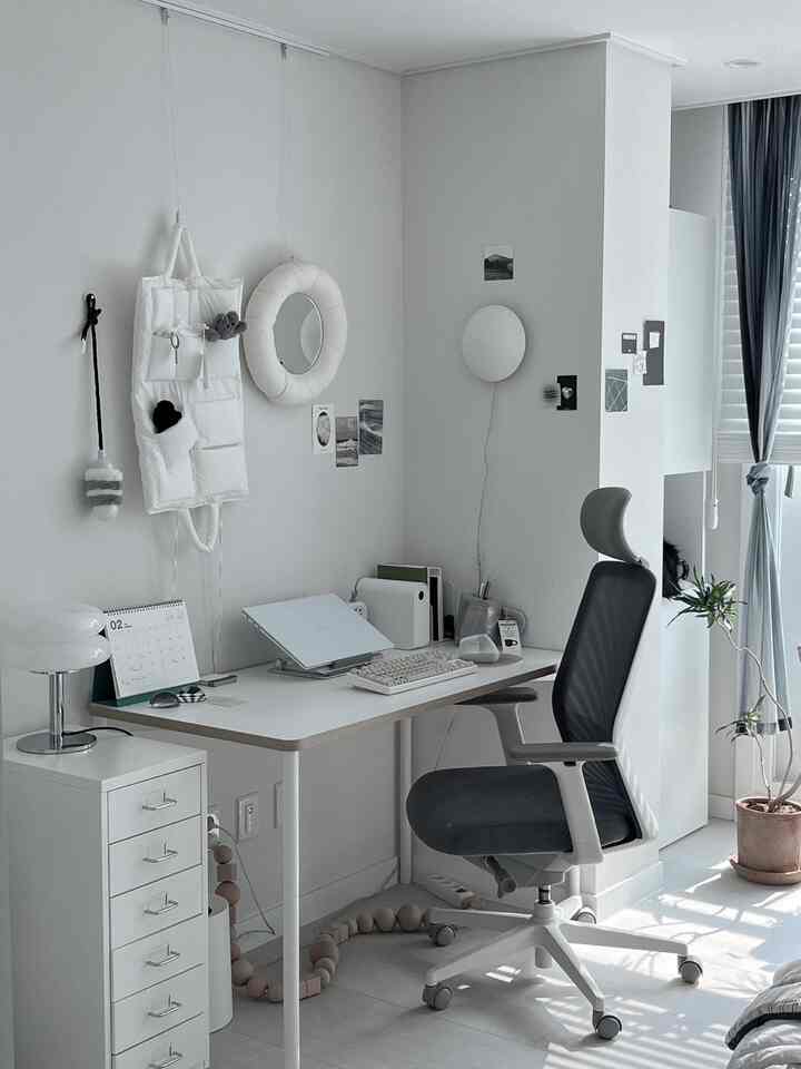 白とグレーのトーンのホームオフィス、机とオフィスチェアが配置された清潔感のある明るい空間