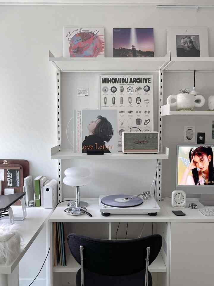 明るく清潔感のある白を基調としたホームオフィス、ターンテーブルと本棚が配置されたミニマルで音楽を楽しむ空間
