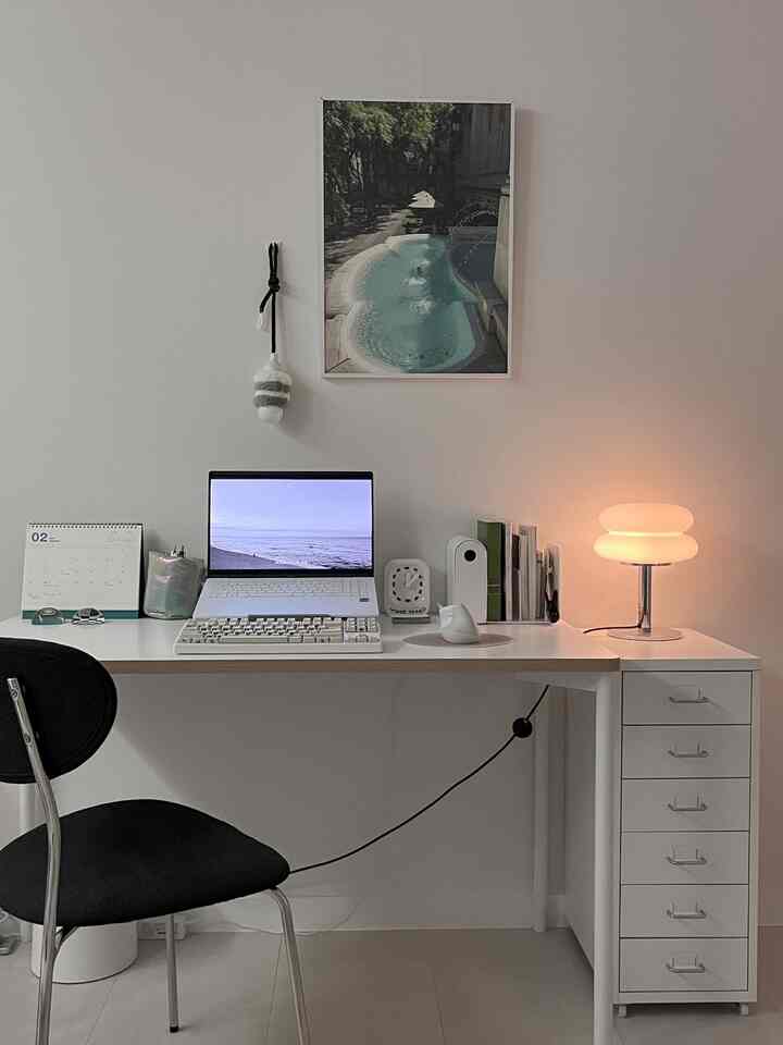 白と黒のトーンのホームオフィス、デスクと椅子、ランプが配置されたミニマルな雰囲気のインテリア