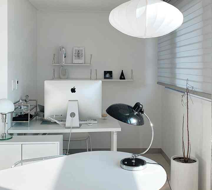 ホワイトトーンのホームオフィス、シンプルなデスクとアップルのiMacが配置されたミニマルなインテリア
