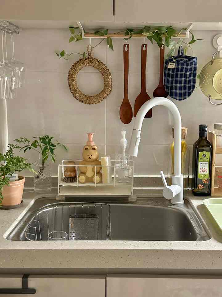 白と木目調の小物が配置されたキッチンシンクの空間、清潔感と自然な雰囲気のあるインテリア