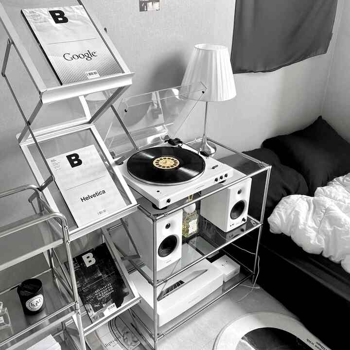 モノトーンでシンプルモダンな寝室、ミニマリストの空間にターンテーブルとスピーカーが配置されたインテリア