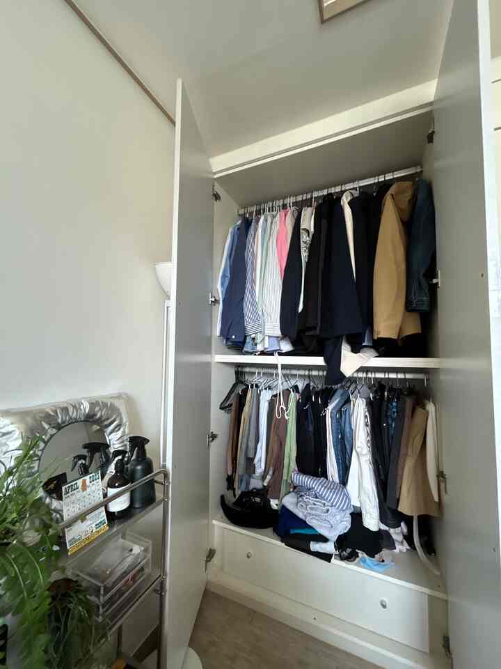 白とナチュラルトーンのクローゼットが配置された整理された収納空間のある部屋