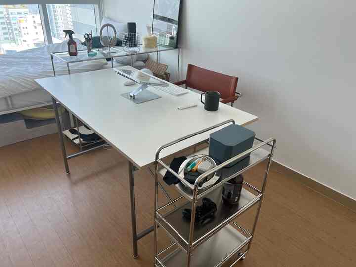 ホワイトトーンとブラウン家具が調和する一人用ホームオフィス空間、ミッドセンチュリーモダンスタイルのデスクとチェアが配置されている。