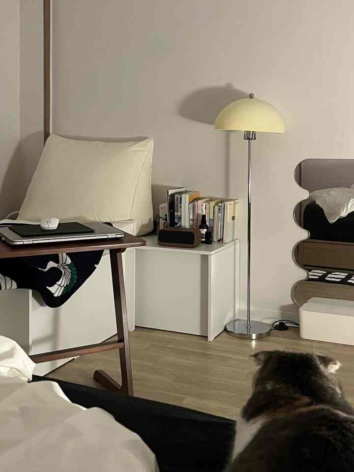 ナチュラルカラーのリビング、ベンチとクッション、フロアランプが配置された雰囲気のあるインテリア