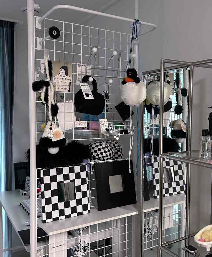 白と黒のトーンのパーティション空間、ユニークなアクセサリーとチェッカーボードミラーが配置されたモダンなインテリア