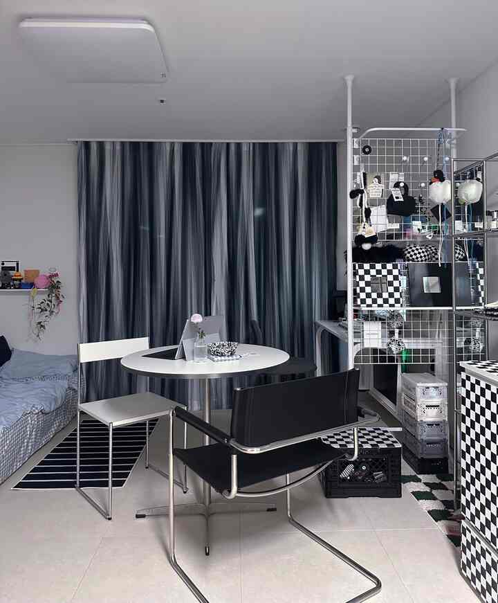 モノトーンでモダンなスタイルの一人暮らし用ワンルーム寝室、収納アイデアが際立つ整った空間