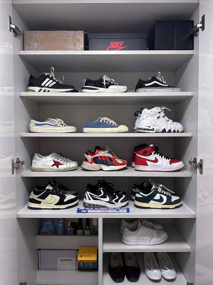 白を基調としたシューズラックが中央に配置され、さまざまなブランドのスニーカーが整然と並んでいる印象的な空間