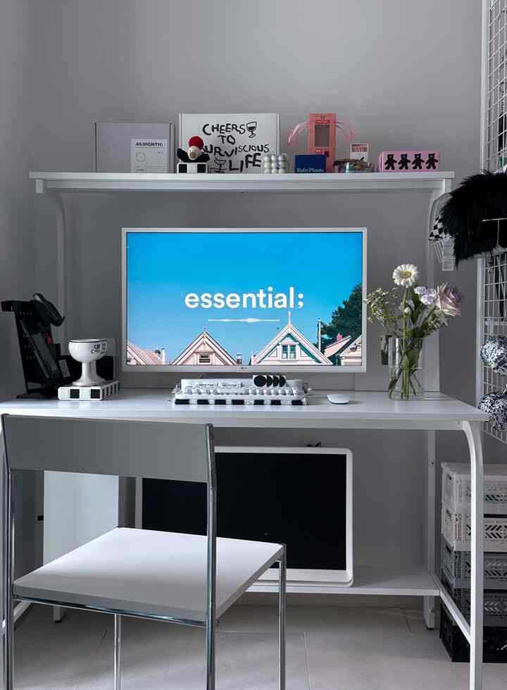 白を基調としたホームオフィス、中央にモニタースタンドと白いデスクが配置された整然としたインテリア