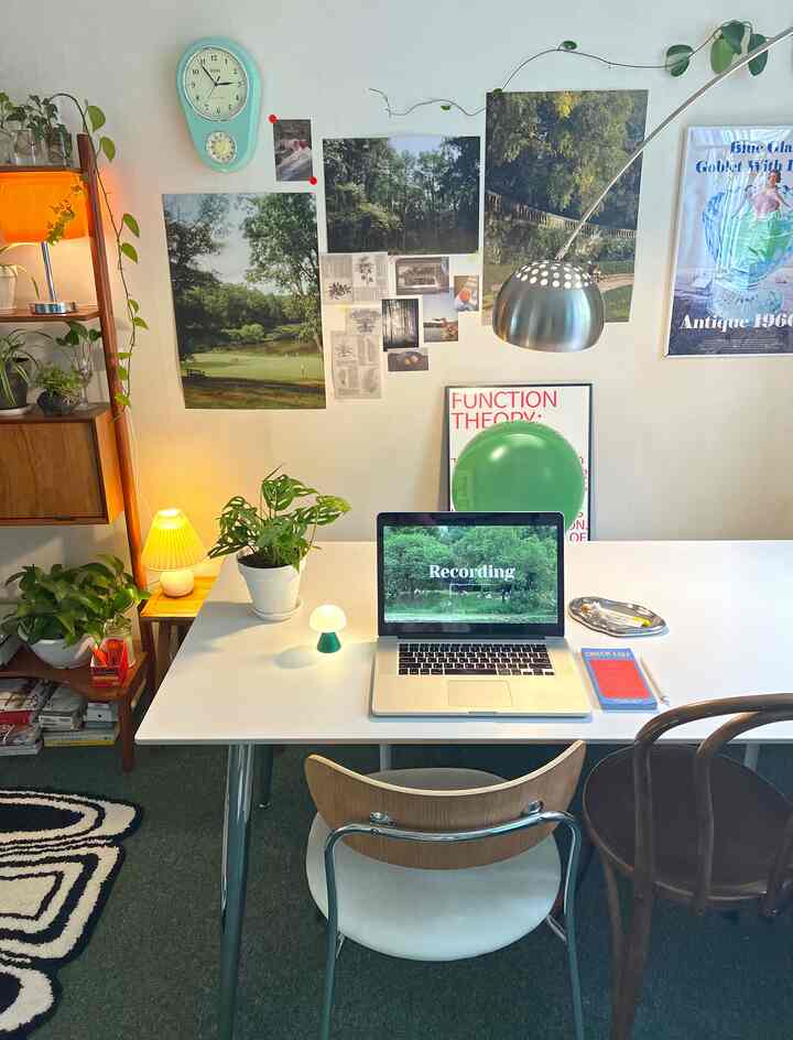 白と緑の調和が美しいミッドセンチュリーモダンリビングルーム、ダイニングテーブルと椅子、壁の装飾や植物が配された雰囲気のあるインテリア