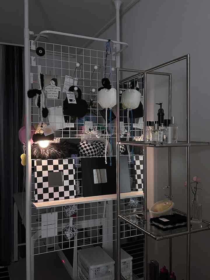 白と黒のトーンの狭い部屋、収納と鏡が配置されたモダンなインテリア小物の空間